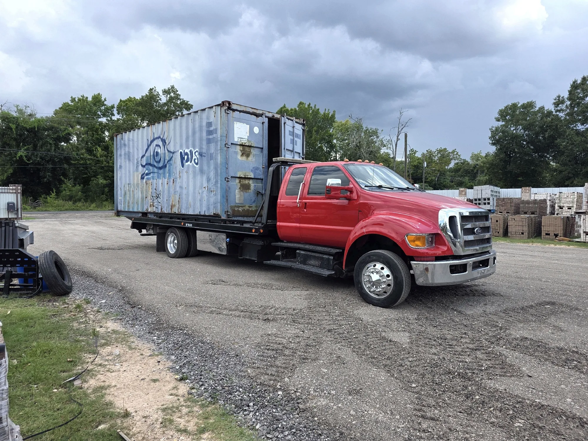 DMC flatbed carrying a 20-foot shipping container